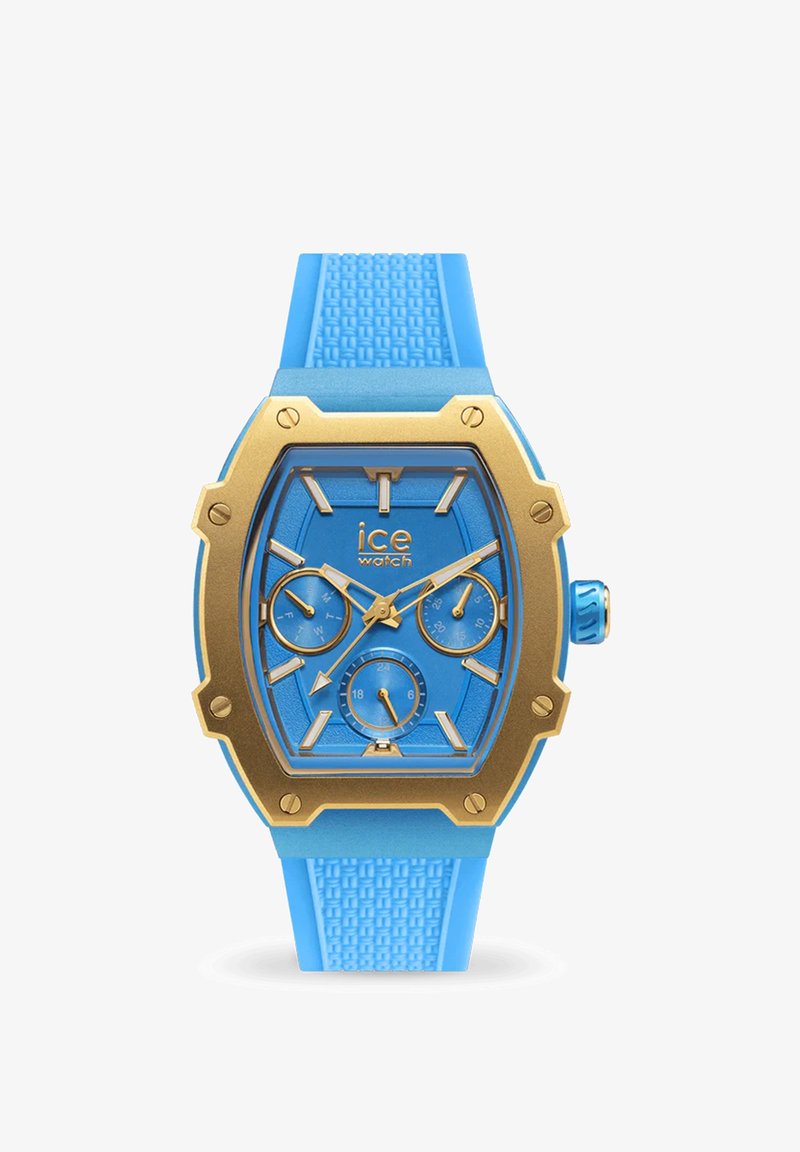 Zila silikona siksna pulkstenis ar zeltainu nerūsējošā tērauda rāmi, kas satur zilu korekciju, trīs subdials un teksturētu apdari siksnī.