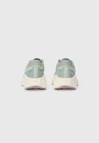 Groene sportieve schoenen met een gestructureerde mesh bovenkant, lichtcrème tussenzool en rubberen buitenzool. Heeft merknaam op de hiel en een gevoerd kraagje.