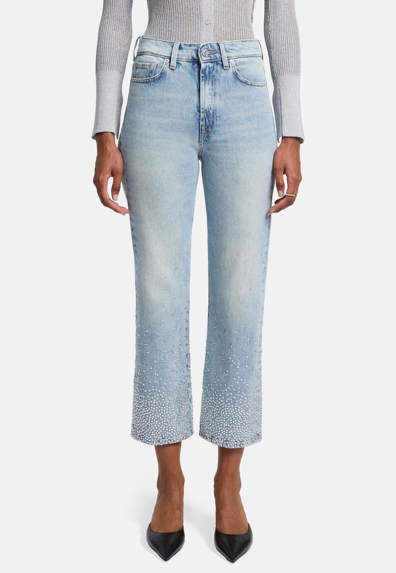 Jeans in denim azzurro chiaro con un taglio cropped e a gamba larga. Orlo inferiore decorato con scintillanti strass, caratterizzati dal classico design a cinque tasche.