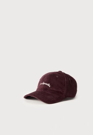 Casquette de baseball en velours côtelé bordeaux, à visière incurvée et ornée d’une petite inscription brodée blanche, sur un fond uni et clair.