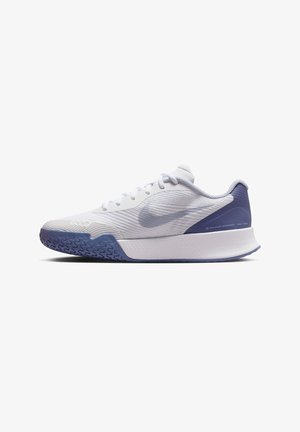Zapatilla deportiva blanca con parte superior de malla texturizada, suela de goma que presenta un acento azul en el talón y un diseño liso y soporte.