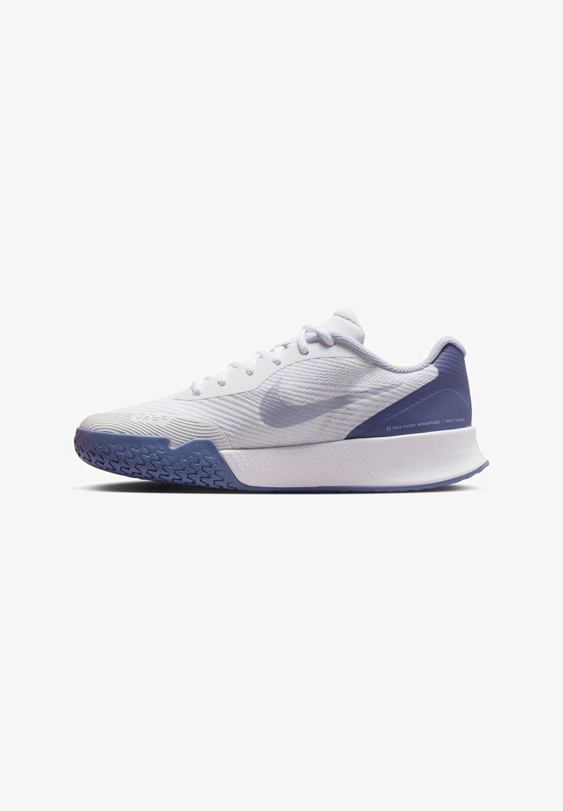 White athletic shoe with textured mesh upper, rubber sole featuring a blue accent at the heel, and a smooth, supportive design.