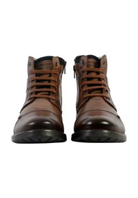 Stivali alla caviglia in pelle marrone con punta rotonda, design con lacci, dettagli in tessuto nero, suole robuste e cerniere laterali per una facile calzata.