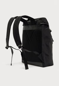 Μαύρο σακίδιο με υφασμάτινη πλέξη σε πάνελ, επενδεδυμένους ιμάντες και κομψό σχήμα. Διαθέτει φερμουάρ και ενισχυμένο πάτο. Ελαφρύ σχέδιο.