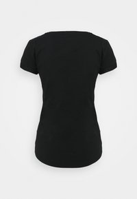 Svart kortärmad t-shirt med rund hals, tillverkad av bomull. Tyget har en slät struktur, med uppvikt ärmar och en figurnära passform.