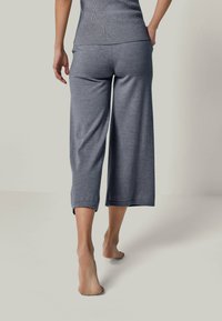 Gray, wide-leg culotte pants made from soft fabric, featuring a ribbed waistband and cropped length, with rolled hems for a relaxed fit.