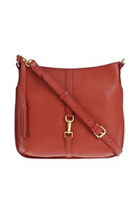 Sac en cuir rouge porté travers avec une sangle réglable, boucle et fermoir dorés, et un détail de pompon sur le côté.