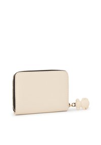 Cartera beige con textura y cierre de cremallera, con un pequeño colgante de oso de plástico suave fijado al tirador de la cremallera.