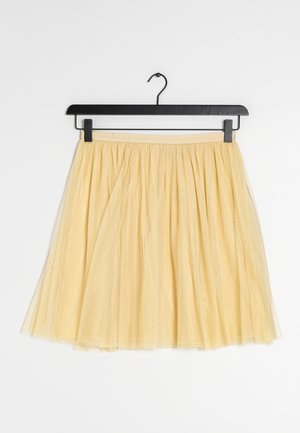 Żółta tiulowa spódnica do kolan z marszczonym paskiem, zawieszona na czarnym klipsie na białym tle.