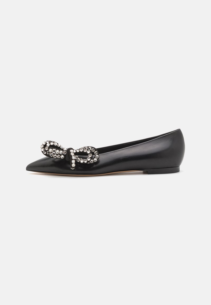 Zapato plano de cuero negro con puntera puntiaguda y un lazo decorativo adornado con rhinestones transparentes en la parte superior. Suela plana de goma.