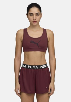Bordoopunane spordirinnahoidja musta logoga, millele on paari lisatud sobivad bordoopunased lühikesed püksid musta vööga, millel on valge "PUMA" tekst. Sile tekstuur.