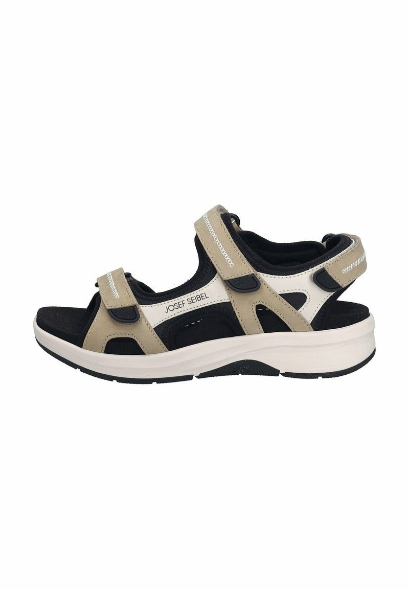 Beige ja must sandaal Velcro rihmadega, avatud varvastega disain, pehme sisetald ja paks valge ja must põhi. Brändi nimi on nähtav.