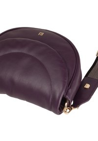 Purple leather crossbody bag with curved design, gold hardware, and a textured stripe strap. Notable embossed brand logo on the front.