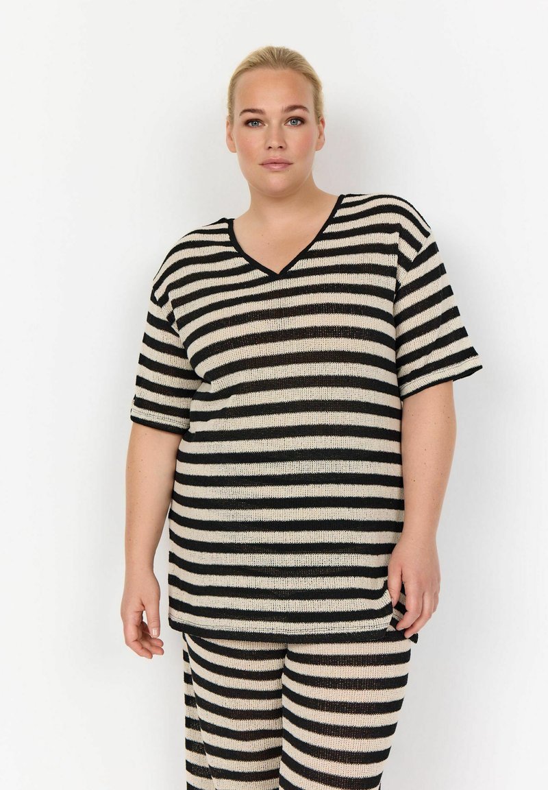 Gestreept gebreid topje in zwart en beige met een V-hals, korte mouwen en een losse pasvorm, gecombineerd met bijpassende gestreepte broek. Geweven stofdetails zichtbaar.