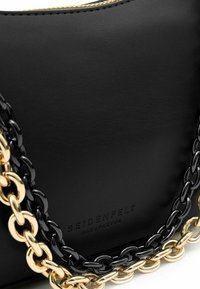 Bolso de cuero sintético negro con acabado texturizado, equipado con una correa de cadena dorada y negra y logotipo en relieve en la parte frontal.