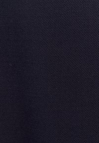 Mörk marinblått tyg med en jämn textur och ett subtilt diagonalt vävda mönster, vilket indikerar ett hållbart material som passar för kläder eller möbelklädsel.