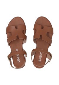 Bruine leren sandalen met twee brede banden en een gespsluiting rond de enkel. Gehydrateerd oppervlak met een platte zool en uitsnijdingen.