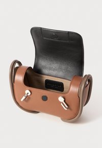 Barna bőr táska fekete bőr fedéllel, ezüst hardware-rel és kontrasztos világosbarna részletekkel. Sleek, téglalap alakú formája van, texturált belső térrel.