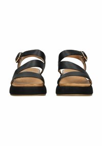 Czarne sandały z krzyżującymi się paskami i sprzączką, z taninowym wkładem i trwałą czarną, teksturowaną podeszwą.