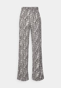 Zwart-witte gekleurde broek met een wijd beenontwerp en elastische tailleband. De stof heeft een gestructureerd, zigzagpatroon over de hele lengte.