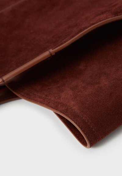 Καφέ σουέτ υλικό με λεία υφή, με καμπύλες άκρες και διακριτές ραφές. Χωρίς ορατά μεταλλικά μέρη ή επιπρόσθετες λεπτομέρειες.