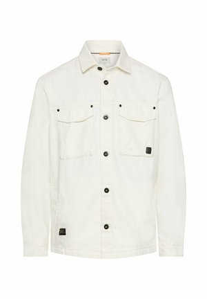 Hvid denimjakke med knapper, to brystlommer med klap, sorte knapper og et lille sort logoemblem på den forreste kant.