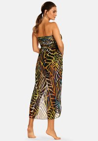 Sukienka maxi bez ramiączek z kolorowymi wzorami liści na przezroczystym materiale, z dopasowaną górą i swobodną spódnicą, sięgająca do kostek.