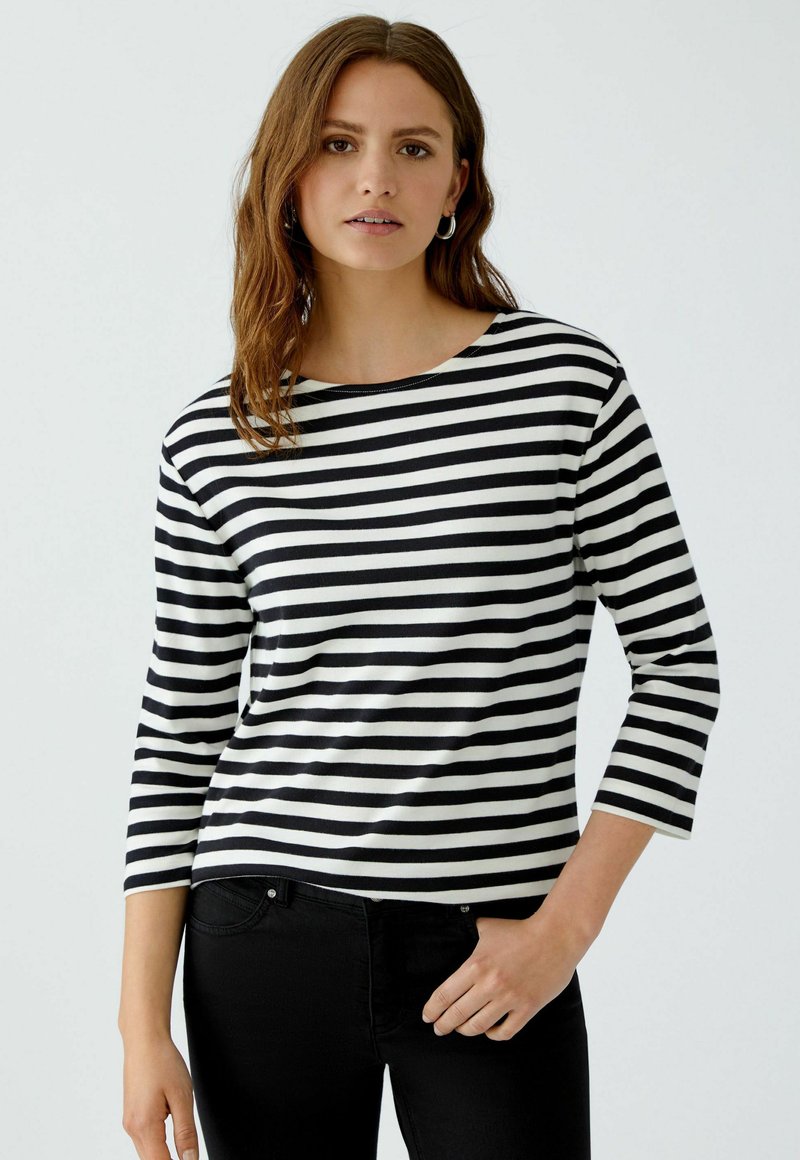 Schwarz-weißer gestreifter Langarmoberteil mit Rundhalsausschnitt und Dreiviertelärmeln. Hergestellt aus einem glatten, leichten Stoff.