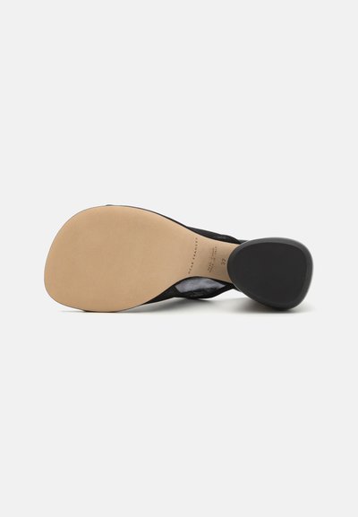 Schwarzer, hochhackiger Schuh mit einer glatten, runden Zehenpartie und einem strukturierten Mesh-Obermaterial. Die Sohle ist hellbeige mit einem schwarzen Absatzakzent.