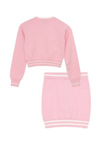Completo due pezzi lavorato a maglia rosa, composto da un maglione corto e una gonna aderente, entrambi con accenti bianchi a righe sui polsini e sull'orlo.
