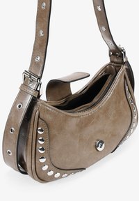 Bolso de hombro de cuero sintético marrón con tachuelas plateadas, forma curva, cierre superior con cremallera y correa desmontable.