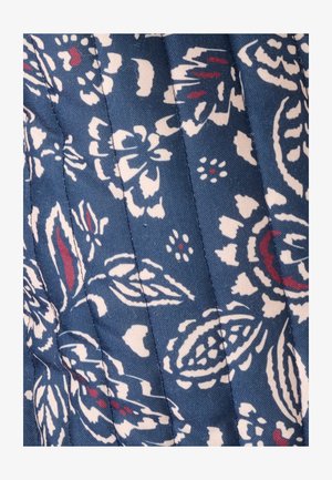 Gewatteerde stof met een donkerblauwe achtergrond en bloemenpatronen in wit en karmozijnrood. De textuur is glad met zichtbare stiksels.