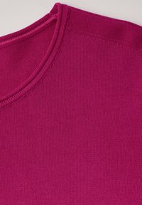 Tessuto lavorato a maglia fucsia con scollatura rotonda, texture liscia e cuciture uniformi, che evidenziano il colore vivace e il design senza soluzione di continuità.