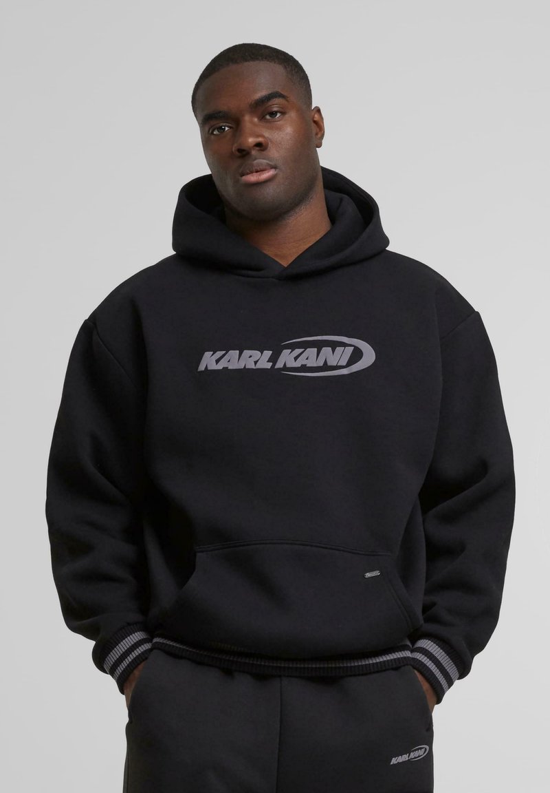 Black hoodie featuring the "KARL KANI" logo in gray, made of soft material, with a large front pocket and striped cuffs.