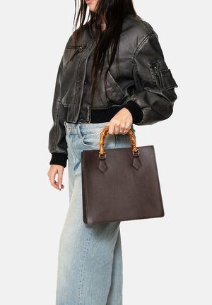Brown leather handbag with a structured shape, featuring a glossy tortoiseshell handle and diamond-shaped hardware accents.