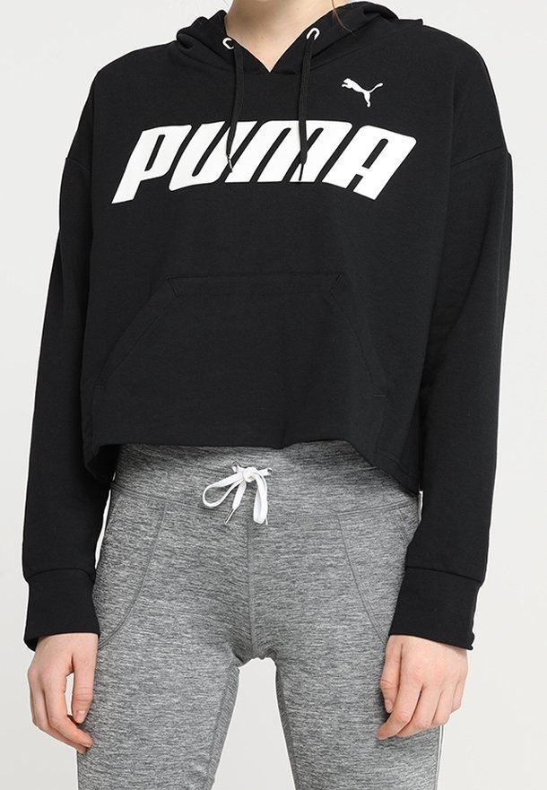 Felpa corta nera con logo bianco "PUMA", cappuccio regolabile con cordino e tasca frontale, abbinata a leggings sportivi grigi.
