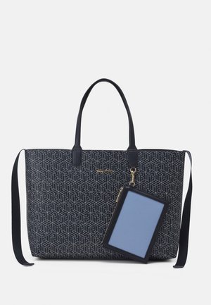 Sort mønstret shopper med dobbelte håndtag og aftagelig skulderrem, med fastgjort navyblåt kortholder med lås i guldfarve.