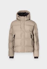 Μπεζ μπουφάν με φουσκωτό ύφασμα, ψηλό γιακά, μαύρο εσωτερικό, δύο τσέπες με φερμουάρ και υφασμάτινη επένδυση με ραφές για μόνωση. Χωρίς ορατή επωνυμία.