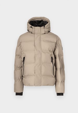 Bēšs pūkains jaka ar augstu apkakli, melnu oderi, divām kabatām ar rāvējslēdzēju un šūtu virsmu izolācijai. Bez redzamas zīmola etiķetes.