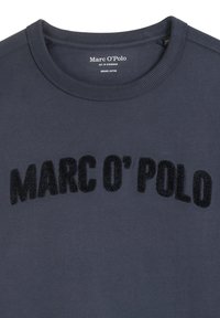 Felpa di cotone biologico blu navy con colletto a girocollo a coste. Presenta la scritta in rilievo, morbida, di colore nero "MARC O’POLO" sul petto.