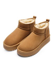 Pair of brown suede ankle boots with thick rubber soles and cream-colored fleece lining, designed for warmth and comfort.