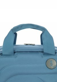 Borsa isolante blu con tessuto texturizzato, manici corti e un accento metallico circolare. Chiusura con zip sulla parte superiore. Design durevole e compatto.