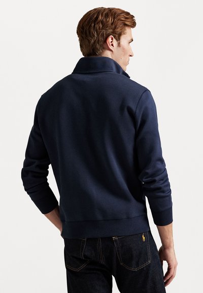 Mørkeblå sweatshirt med høj krave, ribbede manchetter og kant. Materialet fremstår blødt med en glat overflade. Alsidigt design til casual brug.