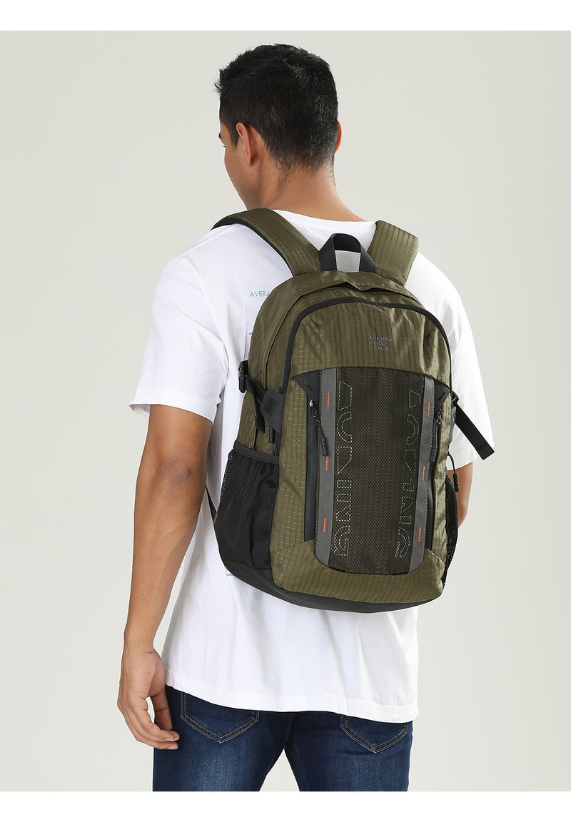 Zaino verde oliva con tessuto testurizzato, dettagli neri, diversi scomparti, spallacci regolabili e fondo rinforzato per una maggiore durata.