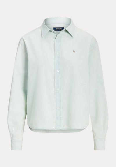 Lyseblå langærmet skjorte med knapper og krave, med lille broderet Polo Ralph Lauren-logo på brystet og synlige hvide knapper foran.