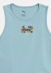 Lyseblå ærmeløs top med Puma-logo omgivet af røde, gule og orange blomster på brystets midte.