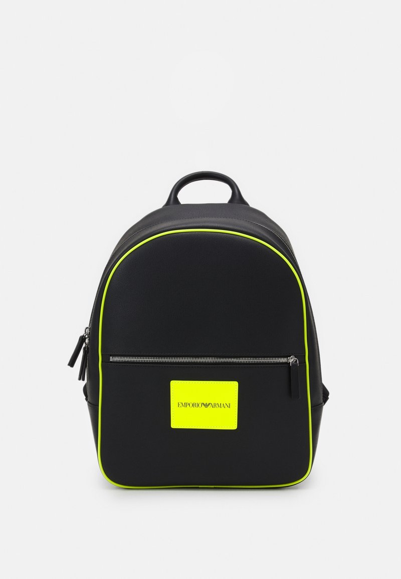 Svart Emporio Armani-ryggsäck med neongul trim, framficka med dragkedja och neongul logotyp på en vit bakgrund.