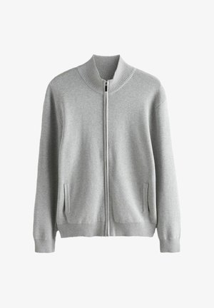 Siva pletena jopica z zadrgo spredaj, rebrastim ovratnikom in stranskimi žepi. Mehak material, sproščen kroj in brez vidnih vzorcev ali logotipov.