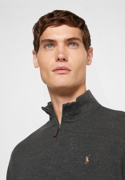 Pullover cinzento de zip parcial, feito de um tecido de malha suave, com um pequeno logótipo bordado no lado esquerdo do peito e um acabamento texturizado.