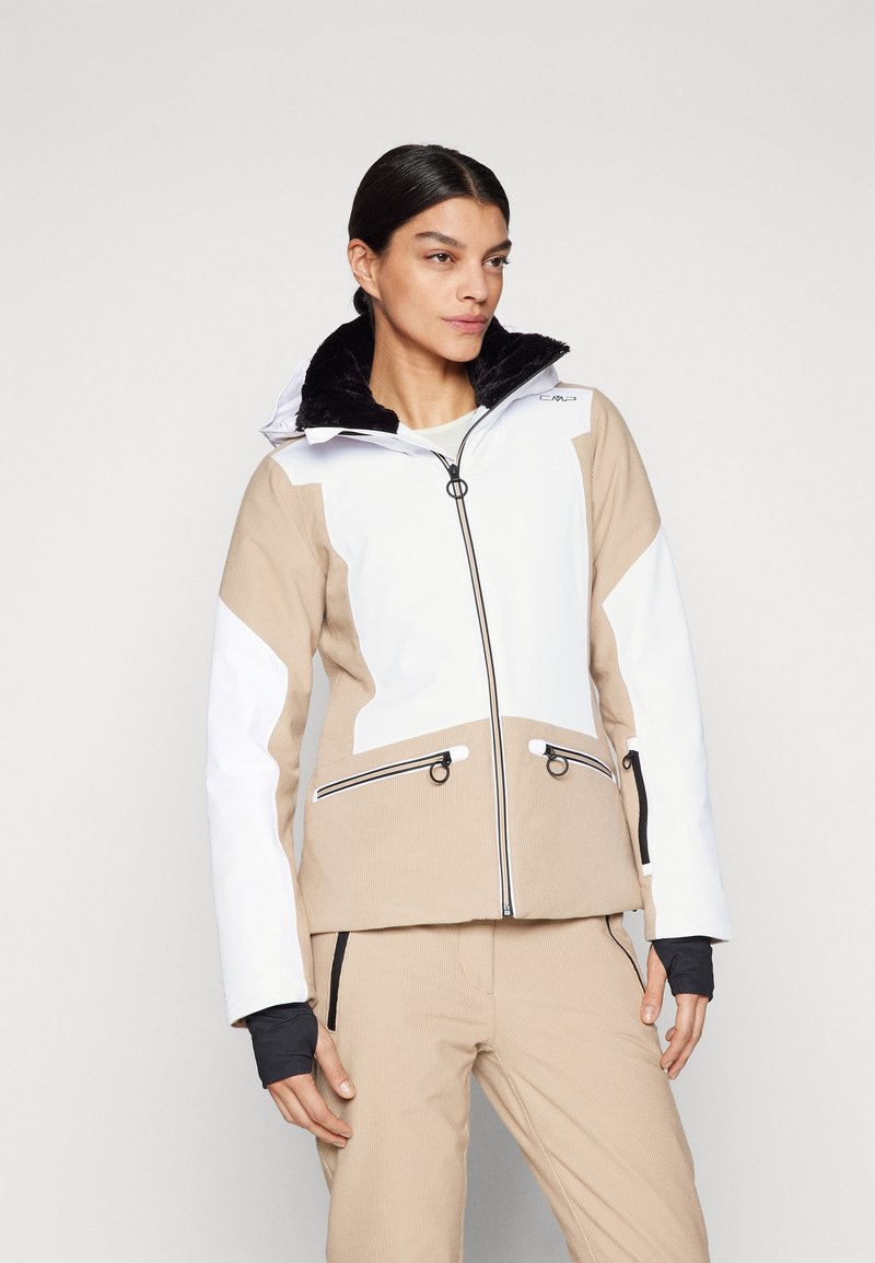 Beige und weiße Skijacke mit strukturiertem Finish, ausgestattet mit einem schwarzen Kunstfellkragen, Reißverschlüssen und kontrastierenden schwarzen Akzenten.